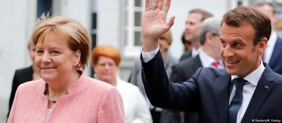 Merkel e Macron durante entrega do prêmio Carlos Magno ao presidente francês, em maio