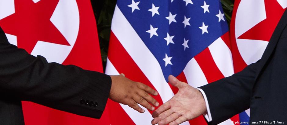 Líder norte-coreano Kim Jong-un (e.) estende a mão para cumprimentar o presidente americano Donald Trump